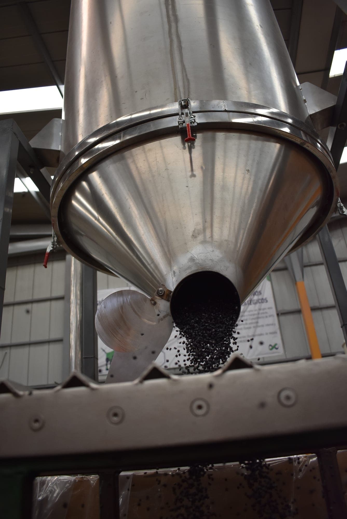 Pellet negro descargándose desde una tolva en la planta de PIMSA